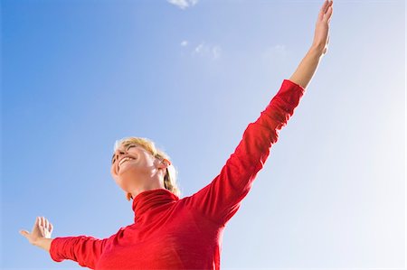 Woman stretching her arms and smiling Stock Photo - Premium Royalty-Free, Code: 6108-05865120