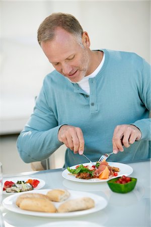 eating fork - Man having breakfast at a dining table Stock Photo - Premium Royalty-Free, Code: 6108-05865289