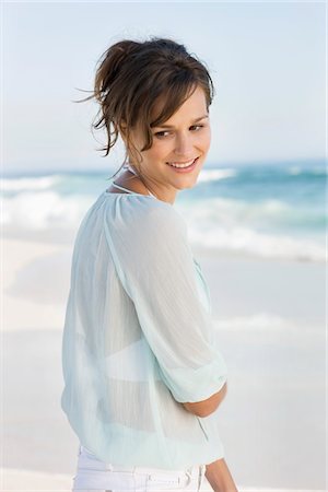 Femme debout sur la plage et souriant Photographie de stock - Premium Libres de Droits, Code: 6108-05865239