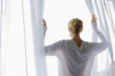 people balcony looking - Rear view of a woman opening the curtain of balcony Stock Photo - Premium Royalty-Free, Code: 6108-05865341