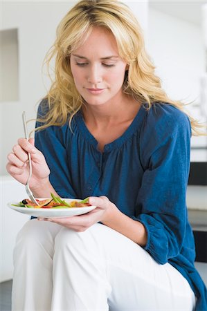 Woman holding a plate of fruit salad Stock Photo - Premium Royalty-Free, Code: 6108-05865373