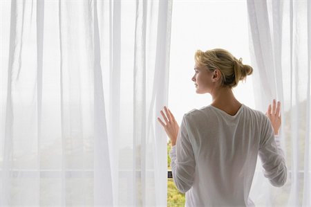 people balcony looking - Rear view of a woman standing on balcony Stock Photo - Premium Royalty-Free, Code: 6108-05865379