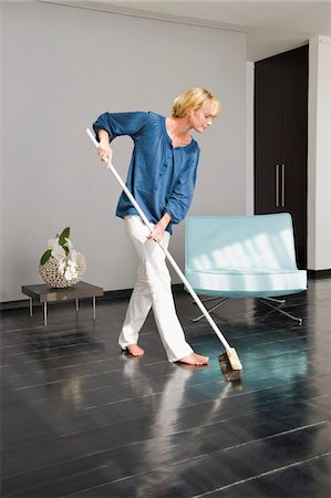 picture of a lady sweeping the floor - Woman cleaning floor with a mop Stock Photo - Premium Royalty-Free, Code: 6108-05865336