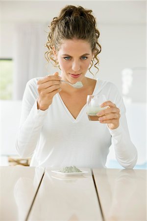 Woman mixing green clay for facial mask Stock Photo - Premium Royalty-Free, Code: 6108-05865466