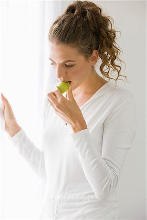 simsearch:6108-05865497,k - Gros plan d'une femme mangeant fruits Photographie de stock - Premium Libres de Droits, Code: 6108-05865483
