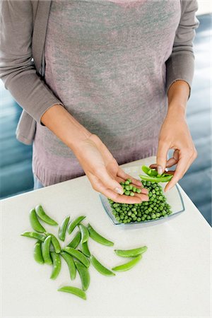 simsearch:6108-05865429,k - Femme pèle les petits pois dans la cuisine Photographie de stock - Premium Libres de Droits, Code: 6108-05865402