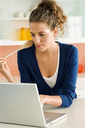 simsearch:6108-05859712,k - Woman reading a recipe on a laptop in the kitchen Foto de stock - Royalty Free Premium, Número: 6108-05865422