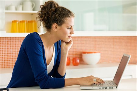 simsearch:632-03424300,k - Woman reading a recipe on a laptop in the kitchen Foto de stock - Sin royalties Premium, Código: 6108-05865439