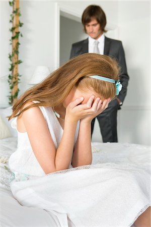 simsearch:6108-05860672,k - Disappointed girl sitting on bed and a groom standing near her Stock Photo - Premium Royalty-Free, Code: 6108-05865553