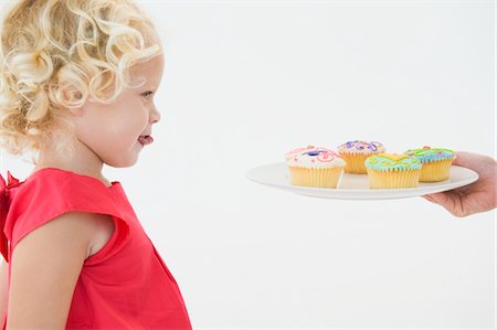 simsearch:6108-05863080,k - Girl looking at cupcakes Foto de stock - Sin royalties Premium, Código: 6108-05865579