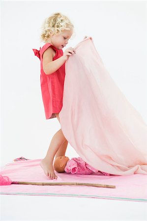 Girl playing with a doll Stock Photo - Premium Royalty-Free, Code: 6108-05865593