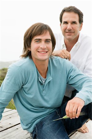 Two men sitting on a boardwalk Stock Photo - Premium Royalty-Free, Code: 6108-05865515