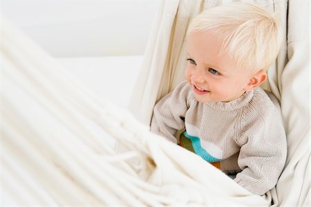 Baby boy sitting in a hammock Stock Photo - Premium Royalty-Free, Code: 6108-05865649