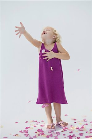 Jeune fille jetant des pétales de fleurs et souriant Photographie de stock - Premium Libres de Droits, Code: 6108-05865608