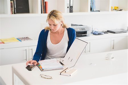 Businesswoman using a calculator Stock Photo - Premium Royalty-Free, Code: 6108-05865749