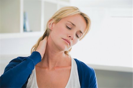 Woman touching her neck Stock Photo - Premium Royalty-Free, Code: 6108-05865752