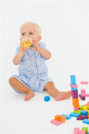 Baby boy drinking juice from a baby bottle Stock Photo - Premium Royalty-Free, Code: 6108-05865704