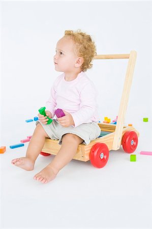 Baby boy sitting on a push cart Stock Photo - Premium Royalty-Free, Code: 6108-05865714