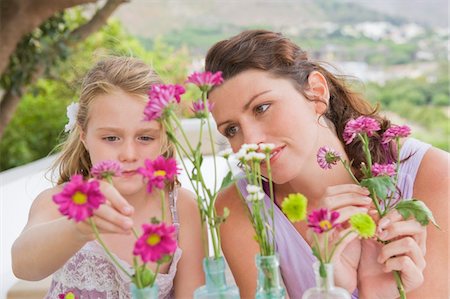 simsearch:6108-05865897,k - Woman with her daughter arranging flowers in a vase Stock Photo - Premium Royalty-Free, Code: 6108-05865874