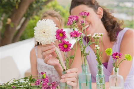 simsearch:6108-05865897,k - Woman with her daughter arranging flowers in a vase Stock Photo - Premium Royalty-Free, Code: 6108-05865886