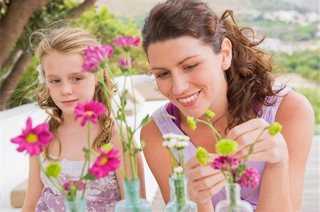 simsearch:6108-05865897,k - Woman with her daughter arranging flowers in a vase Stock Photo - Premium Royalty-Free, Code: 6108-05865890