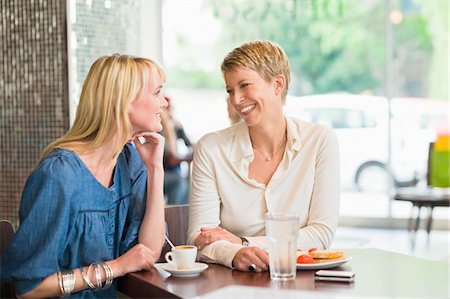 simsearch:6118-07781810,k - Two women sitting in a restaurant and smiling Stock Photo - Premium Royalty-Free, Code: 6108-05865831