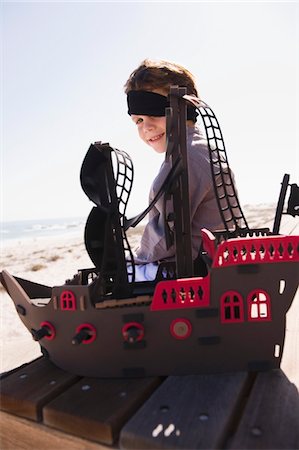 simsearch:6108-05865942,k - Boy in pirate costume playing with a toy boat Foto de stock - Royalty Free Premium, Número: 6108-05865946