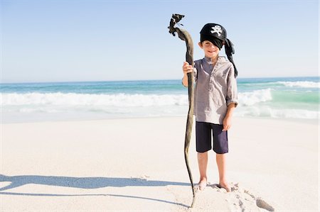 simsearch:6108-05865942,k - Boy in pirate costume standing on the beach Foto de stock - Royalty Free Premium, Número: 6108-05865904