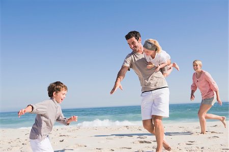 fathers carrying sons on the beach - Family enjoying vacations on the beach Stock Photo - Premium Royalty-Free, Code: 6108-05866051