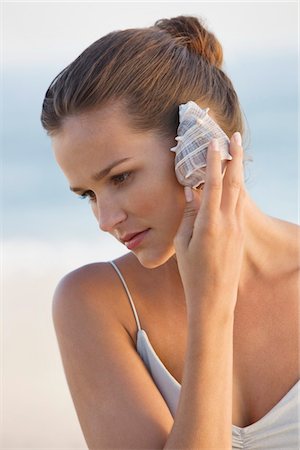 simsearch:6108-05866106,k - Woman listening to a conch shell Stock Photo - Premium Royalty-Free, Code: 6108-05866057