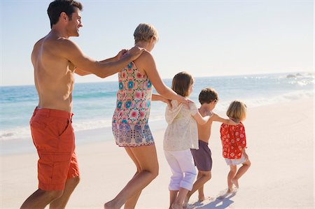 simsearch:6108-05866000,k - Famille marchant sur la plage dans la formation du train Photographie de stock - Premium Libres de Droits, Code: 6108-05866054