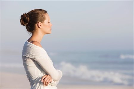 Woman standing on the beach and thinking Stock Photo - Premium Royalty-Free, Code: 6108-05866069