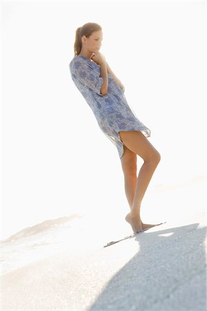 Woman standing on the beach and thinking Stock Photo - Premium Royalty-Free, Code: 6108-05866073