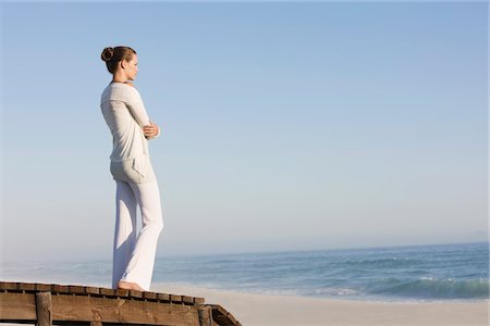 Woman standing on a boardwalk looking at a view Stock Photo - Premium Royalty-Free, Code: 6108-05866081