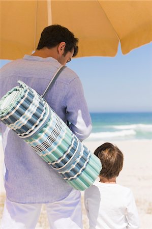 Man with his son on the beach Stock Photo - Premium Royalty-Free, Code: 6108-05866015