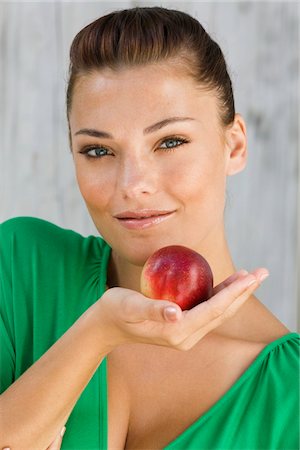 fruit eyes not children - Woman holding an apple and smiling Stock Photo - Premium Royalty-Free, Code: 6108-05866156