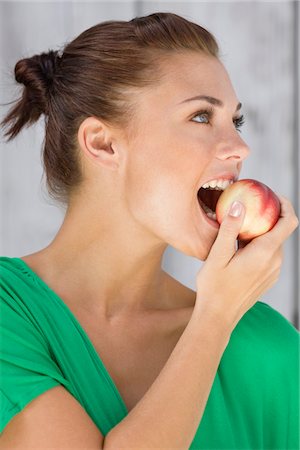 simsearch:6108-05862422,k - Woman eating an apple and smiling Foto de stock - Sin royalties Premium, Código: 6108-05866117