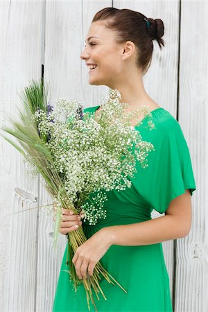 simsearch:6108-05866156,k - Woman holding a bouquet of flowers and smiling Stock Photo - Premium Royalty-Free, Code: 6108-05866121