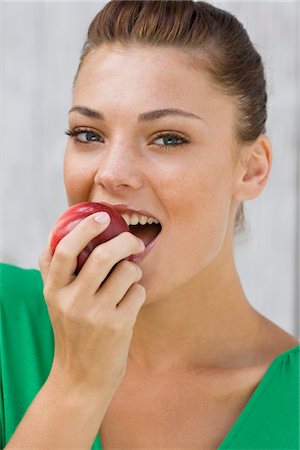 simsearch:6108-05862422,k - Woman eating an apple and smiling Foto de stock - Sin royalties Premium, Código: 6108-05866135
