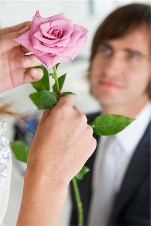 elegant man party - Woman holding a flower in front of a man Stock Photo - Premium Royalty-Free, Code: 6108-05866240