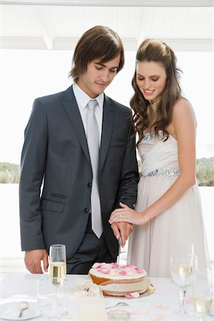 someone cutting cake - Newlywed couple cutting a wedding cake Stock Photo - Premium Royalty-Free, Code: 6108-05866289