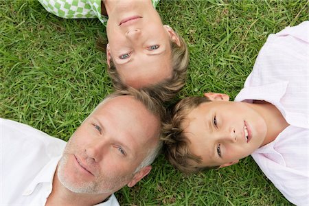 father son lying grass - Boy with his parents lying on grass in a park Stock Photo - Premium Royalty-Free, Code: 6108-05866375