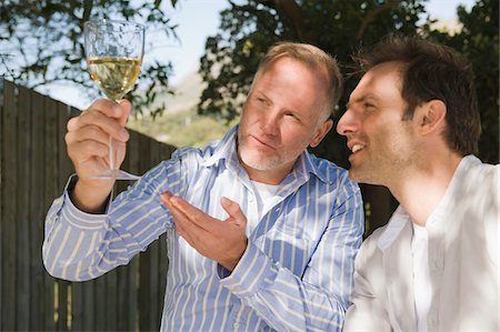 simsearch:6108-05874120,k - Deux amis en regardant un verre de vin Photographie de stock - Premium Libres de Droits, Code: 6108-05866312