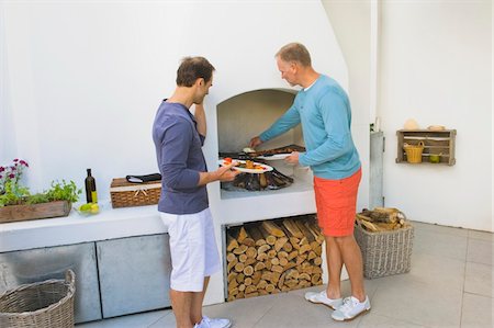 Two men cooking kebab at fireplace Stock Photo - Premium Royalty-Free, Code: 6108-05866329