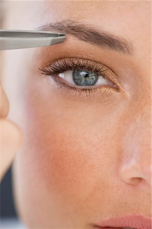 Portrait of a woman tweezing eyebrows Stock Photo - Premium Royalty-Free, Code: 6108-05866482