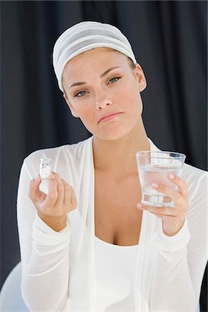 simsearch:6108-05863527,k - Femme tenant une bouteille de médicament avec un verre d'eau Photographie de stock - Premium Libres de Droits, Code: 6108-05866493