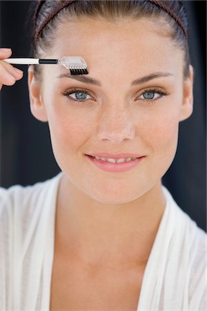 simsearch:6108-05866499,k - Porträt einer Frau, die Augen Make-up anwenden Stockbilder - Premium RF Lizenzfrei, Bildnummer: 6108-05866491