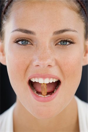 eye care medicine - Portrait of a woman taking an Omega-3 capsule Stock Photo - Premium Royalty-Free, Code: 6108-05866494