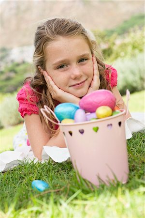 easter grass - Container of Easter eggs in front of a girl Foto de stock - Royalty Free Premium, Número: 6108-05866417