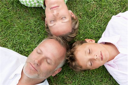 father son lying grass - Boy with his parents lying on grass in a park Stock Photo - Premium Royalty-Free, Code: 6108-05866423